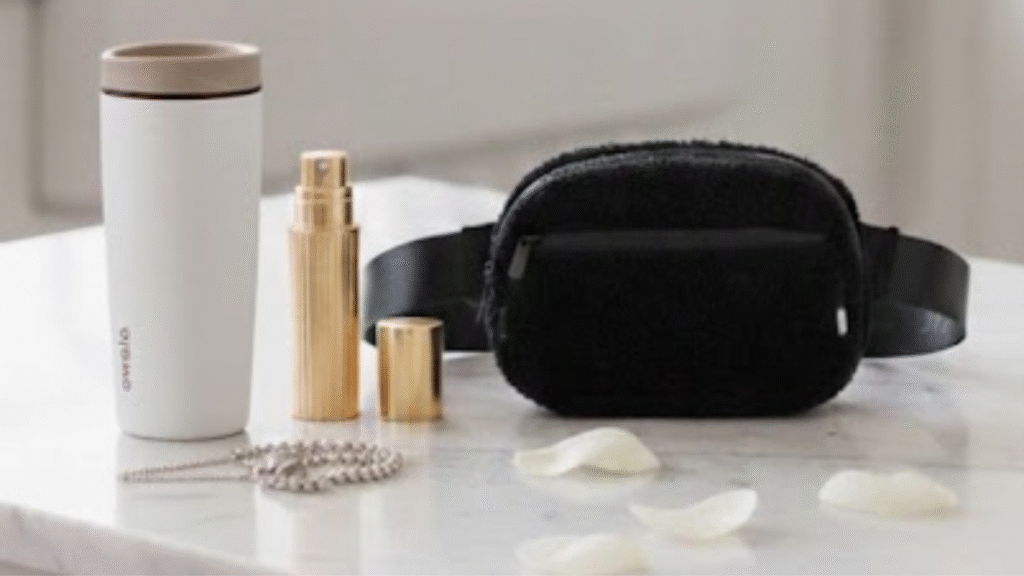 A stylized scene inspired by products featured in chapter 4 of the holiday wishbook. A fuzzy crossbody bag, a stylish travel tumbler, a gold travel perfume atomizer.